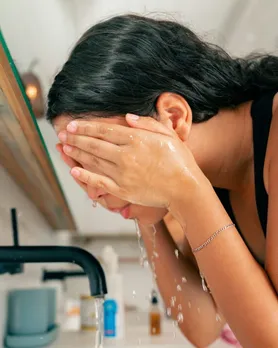 A woman washing her face using a non foaming cleanser