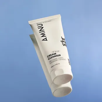 A picture of a white tube with non foaming cleanser placed on a blue backdrop