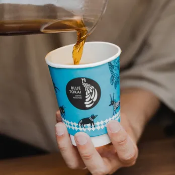 A picture of coffee being poured in the signature blue cup from Blue Tokai Coffee Roasters-one of the best coffee brands in India-to show how luxury coffee brands in India are making it big via home brewing coffee India as well as artisanal coffee India