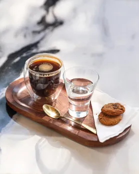 A picture of two different cups of coffee with biscuits on the side to show how luxury coffee brands in India like Pour Over Coffee Roasters are gaining traction with the advent of artisanal coffee India and craft coffee roasters India