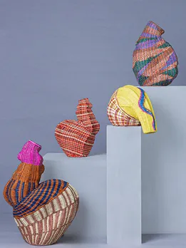 A group of brightly coloured raffia sculptures by Chorus displayed on grey plinths, showcasing the label’s expansion into sculptural home objects