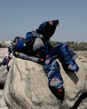Large padded quilted textile structures by Péro placed on a rocky outdoor landscape under clear blue sky