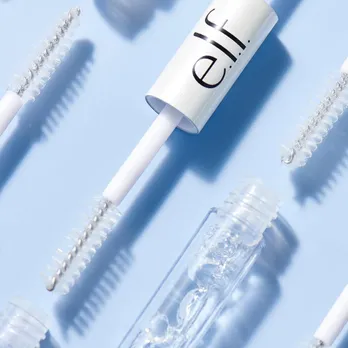 A clear brow gel from e.l.f Cosmetics placed on a powder blue backdrop