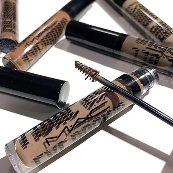 A flatlay shot of some tinted eyebrow gels from M.A.C placed on a white surface