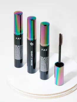 Three eyebrow mascaras placed vertically next to one another on a marble trinket tray