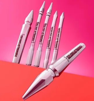 A few eyebrow grooming kit essentials from benefit cosmetics against a white and pink backdrop