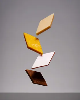 A picture of four different flavours of Kaju Katli at Almond House to show how brands like Almond House are catering to the reign of Kaju Katli in India by adding flavours to the cashew-based Indian sweets