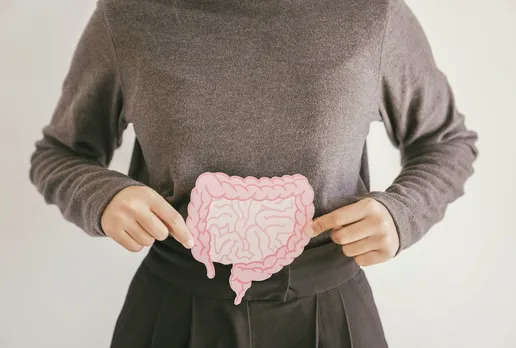 A woman holding the gut's cutout near her stomach