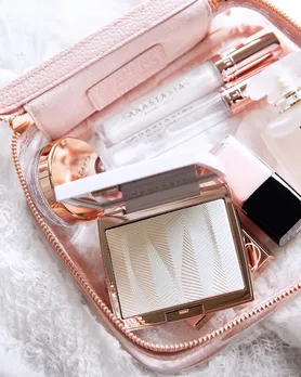 Highlighter powder, brow freeze and gloss from Anastasia Beverly Hills placed on a marble table