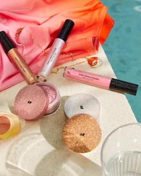 Highlighter powder from H&M placed by the poolside with lipglosses