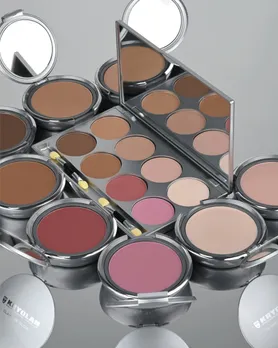 A few pans of make-up palettes placed on a silver tray, including highlighter powder too