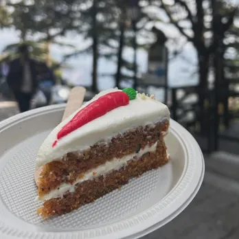 A slice of what's touted as one of the best Christmas Cake in India at Landour Bakehouse against a backdrop of the hills and trees to show how Christmas desserts India go beyond Yule log cake India, Stollen bread India and marzipan India