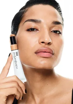 A female model with a skin tint held close to her skin