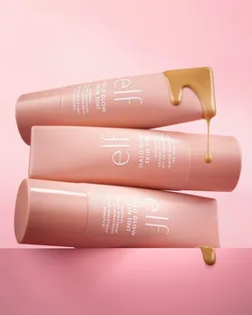 Three bottles of the elf halo glow skin tint stacked on top of each other with a smear of the product on top
