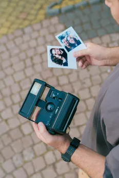 An old-school polaroid camera with photos to show how nostalgia in India is extremely popular, even though its millennial nostalgia and not Gen Z nostalgia, which saw many retro comebacks 2025