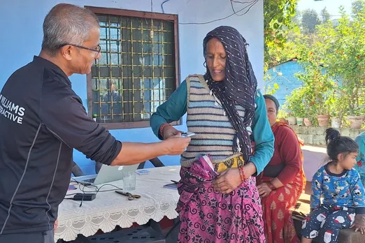 A Tiya Foundation volunteer assists a villager with a telemedicine consultation, ensuring access to medical expertise despite