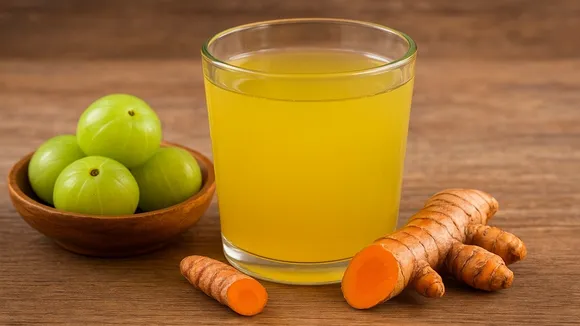 Morning Detox Drink with Amla and Turmeric on wooden table: রোগপ্রতিরোধ শক্তিবৃদ্ধিকারী পানীয়।