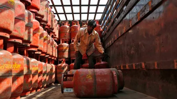 A worker unloads LPG cooking cylinders from a supply truck outside a distribution centre in Ahmedabad