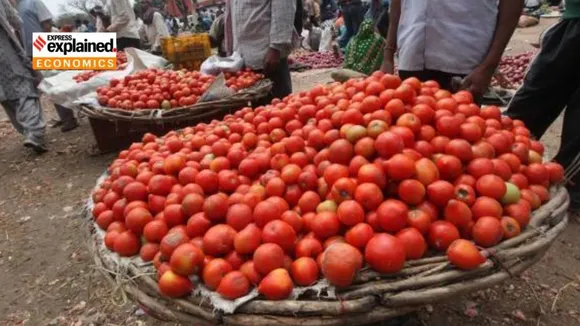 A woman buys tomatoes from a vendor in New Delhi, Tuesday, June 27, 2023.