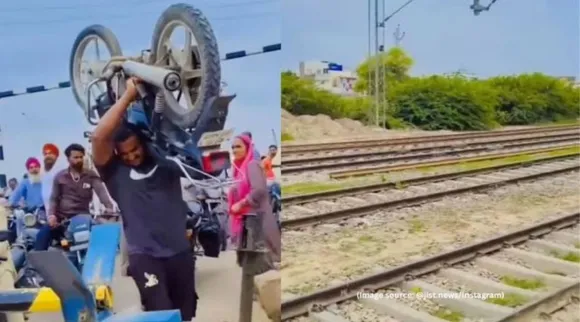 Man lifts bike railway track