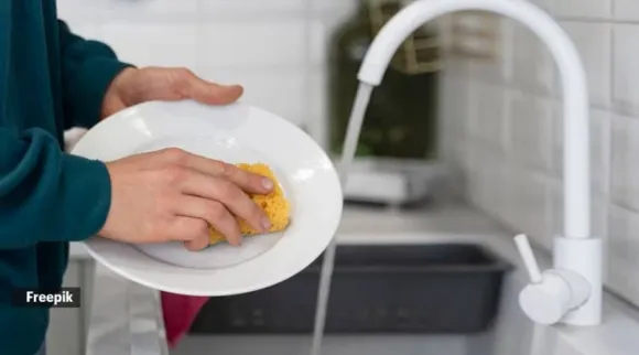 hands washing dish with sponge