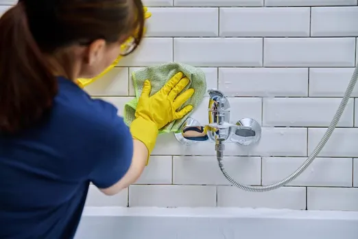woman-cleaning-bathroom-washing-faucet-tile-with-professional-cloth-foam-cleaner_116407-33623