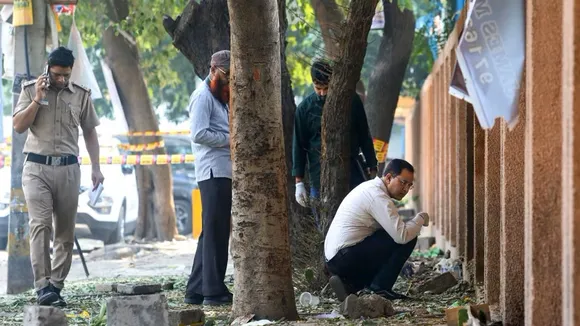 Forensic experts collect samples from the site after a blast was reported at Prashant Vihar, near CRPF school in Rohini area of New Delhi on Sunday