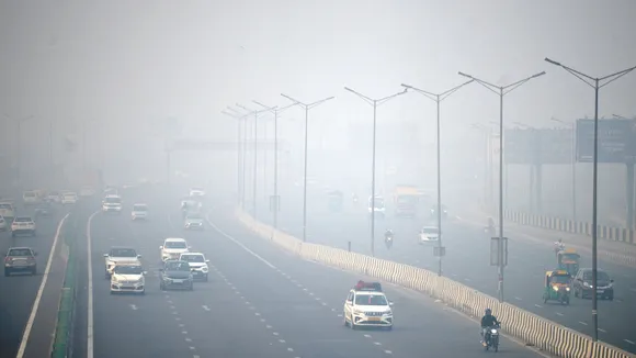 Vehicles move on a road amid low visibility due to smog, in New Delhi