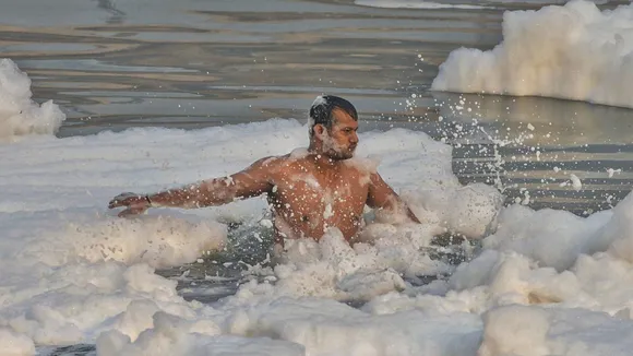 A devotee takes holy dip in the Yamuna river as toxic foam floats on the surface of the polluted river during the start of the 4-day Chhath Puja festival, at Kalindi Kunj in New Delhi, Tuesday, Nov 5, 2024.