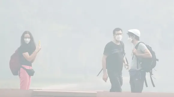 Visitors stroll through the lawns of the Kartavya Path during smog, in New Delhi