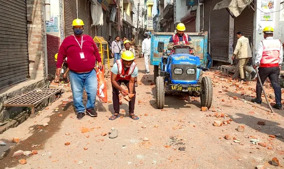 Workers remove brick bats from a road after violence erupted during the second survey of the Jama Masjid, claimed to be originally the site of an ancient Hindu temple, in Sambhal, Sunday, Nov. 24, 2024.