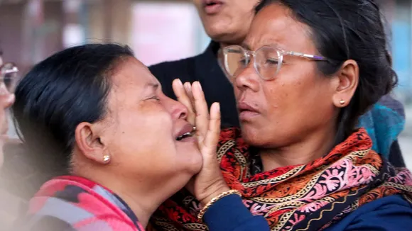 Wife of Laishram Kamalbabu, who allegedly went missing from an army camp, being consoled as she breaks down during a protest in front of the army checkpoint, in Imphal West, Manipur