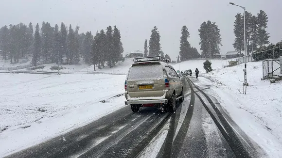 Vehicles move on a road amid light snowfall, in Gulmarg, Sunday, Dec. 8, 2024.