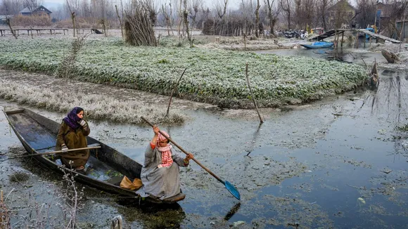 Women row their boat through the partially frozen interior Dal Lake during a cold winter morning, in Srinagar, Saturday, Dec. 14, 2024.