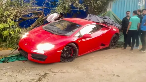 People gather around a Lamborghini car after it allegedly hit people in Noida on Sunday, March 30, 2025.