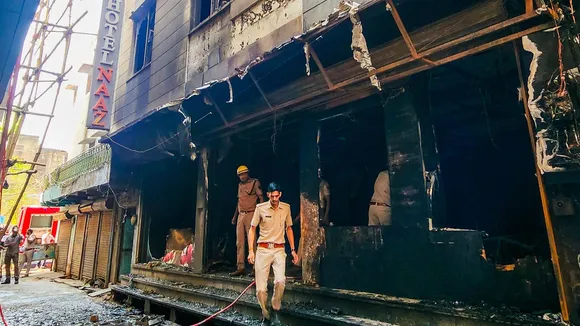 Police and firefighters at the hotel where a fire broke out, in Ajmer.