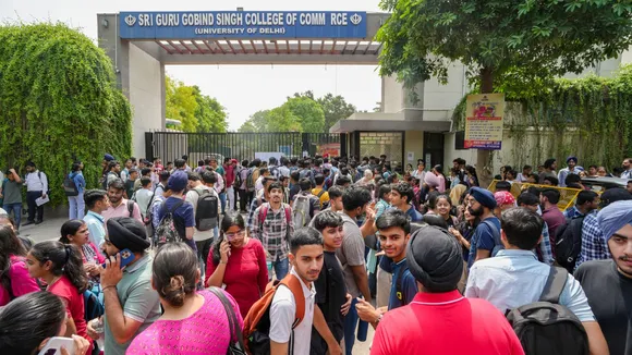 Students wait outside Guru Gobind Singh College of Commerce after a fire broke out in its library, in northwest Delhi's Pitampura.