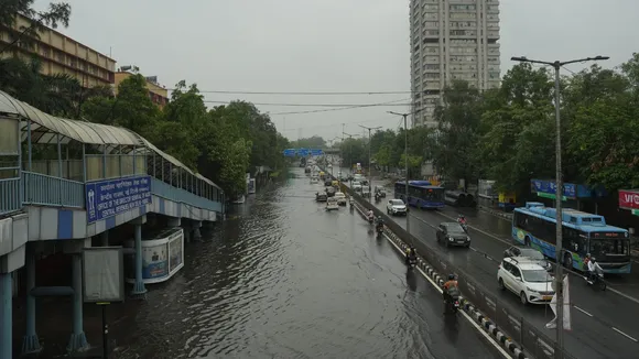 Commuters wade through a waterlogged road following rains, at ITO in New Delhi.