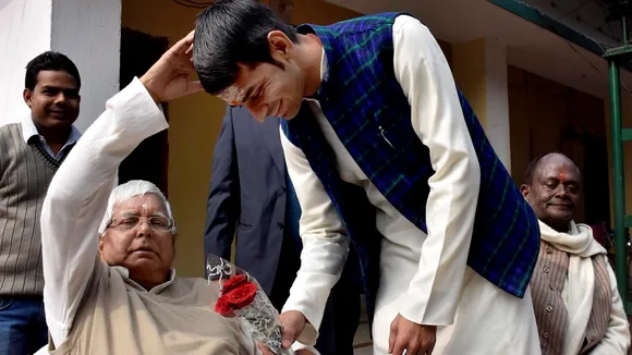 In this Friday, Jan. 1, 2016 file image, RJD leader Tej Pratap Yadav takes blessings of his father and party chief Lalu Prasad, in Patna.