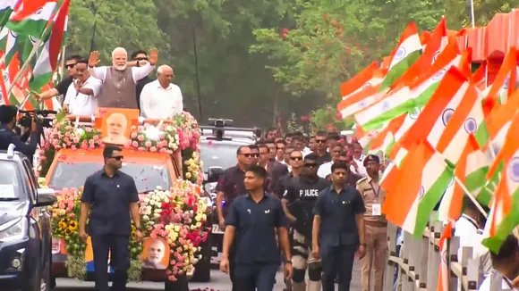 Prime Minister Narendra Modi waves at supporters during a roadshow in Gandhinagar, Gujarat. 