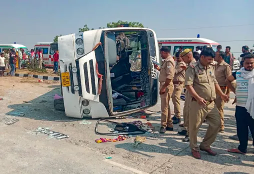Police personnel and others stand near an overturned vehicle after an accident, in Jaunpur, Uttar Pradesh.