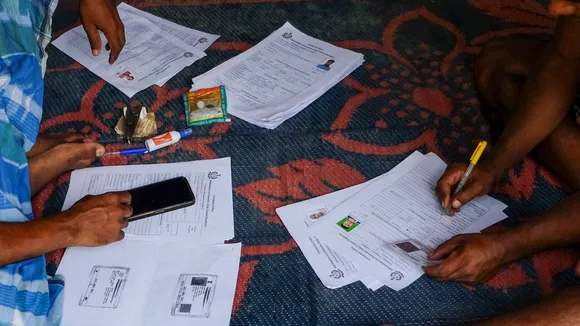 People from West Bengal fill out forms for police verification at a slum area in Gurugram on Friday, July 25, 2025.