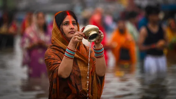 A devotee offers 'arghya' at Sangam on the 'Chhath Puja' festival, in Prayagraj, Monday, Oct. 27, 2025.