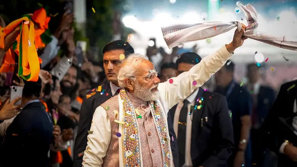 Prime Minister Narendra Modi waves a gamcha as he arrives during the celebration of NDA's victory in the Bihar Assembly elections, at BJP headquarters, in New Delhi, Friday, Nov. 14, 2025.