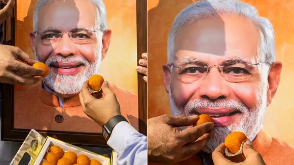 BJP workers offer sweets to a portrait of Prime Minister Narendra Modi in celebration as early trends show the NDA taking the lead during the counting of votes in the Bihar Assembly elections, in Amritsar, Punjab, Friday, Nov. 14, 2025.