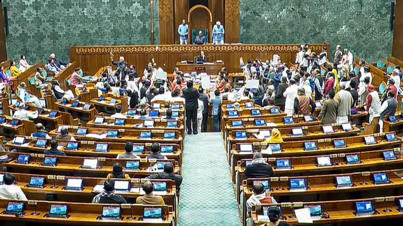 Opposition MPs protest in the well as Union Minister Shivraj Singh Chouhan (unseen) speaks in the Lok Sabha during the Winter session of Parliament, in New Delhi, Thursday, Dec. 18, 2025.
