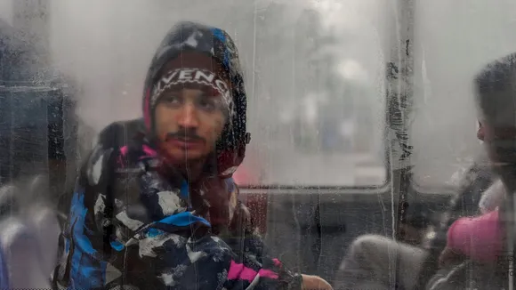 A passenger looks through a window on a cold winter morning, in New Delhi, Tuesday, Jan. 6, 2026.