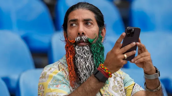 A team India fan with his beard coloured in the country's national flag takes photographs during a practice session ahead of an ICC Men's T20 World Cup 2026 cricket match between India and Pakistan, at R Premadasa Stadium, in Colombo, Sri Lanka, Saturday, Feb. 14, 2026.