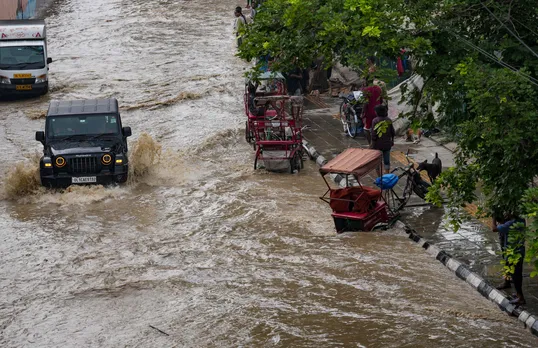 Vehicle move through a flooded road near the Red Fort as the swollen Yamuna river floods low-lying areas, in New Delhi