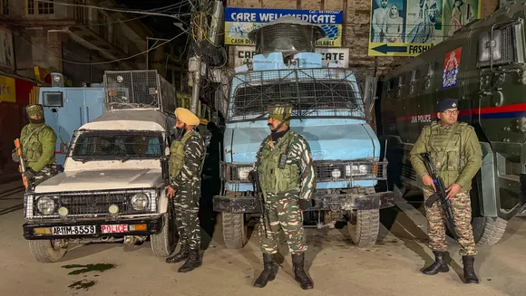 Security personnel stand guard during a cordon and search operation after terrorists shot dead a worker from Punjab